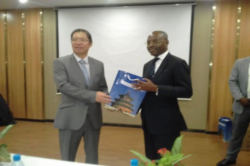 L’ambassadeur de Chine près le Gabon, HU Changchu remettant un présent au Directeur de publication du quotidien L’Union, Lin-Joël Ndembet.